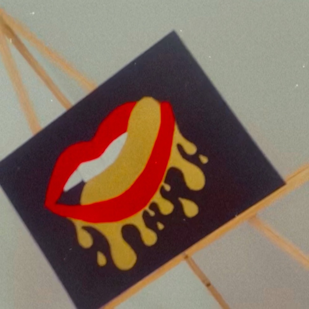 Painting of a mouth with golden drips dripping down the bottom lip.